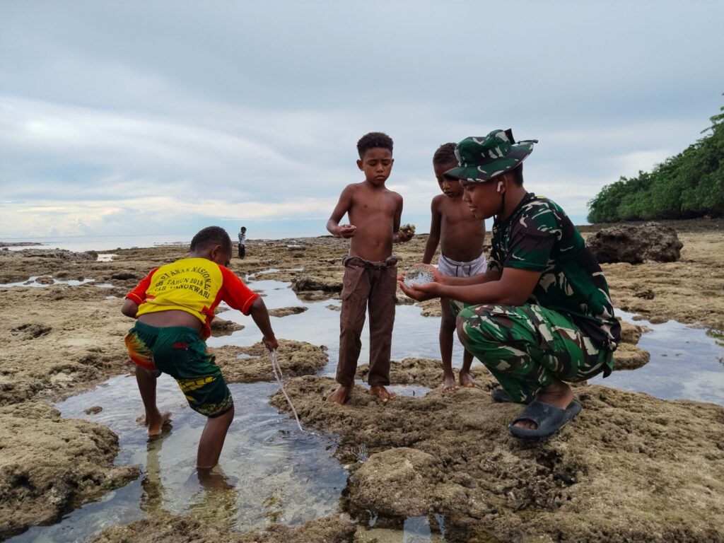 Canda Tawa Anak-anak dan Satgas TMMD Hiasi Aktivitas Cari Ikan di Pantai