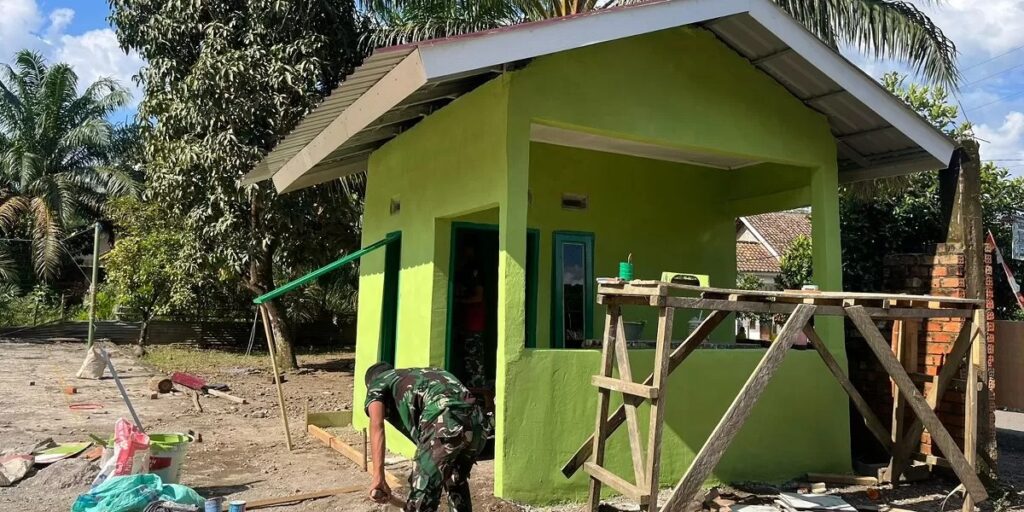Satgas TMMD dan Warga Kompak Aduk Semen Demi Poskamling Desa