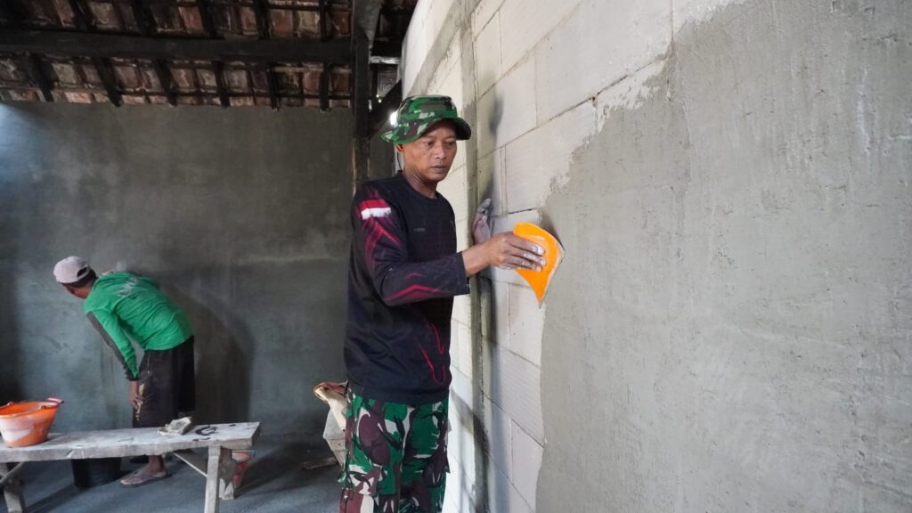 Ketelitian Kopda Mar Azis Saat Plester Dinding Tuai Apresiasi Warga Desa Tlemang