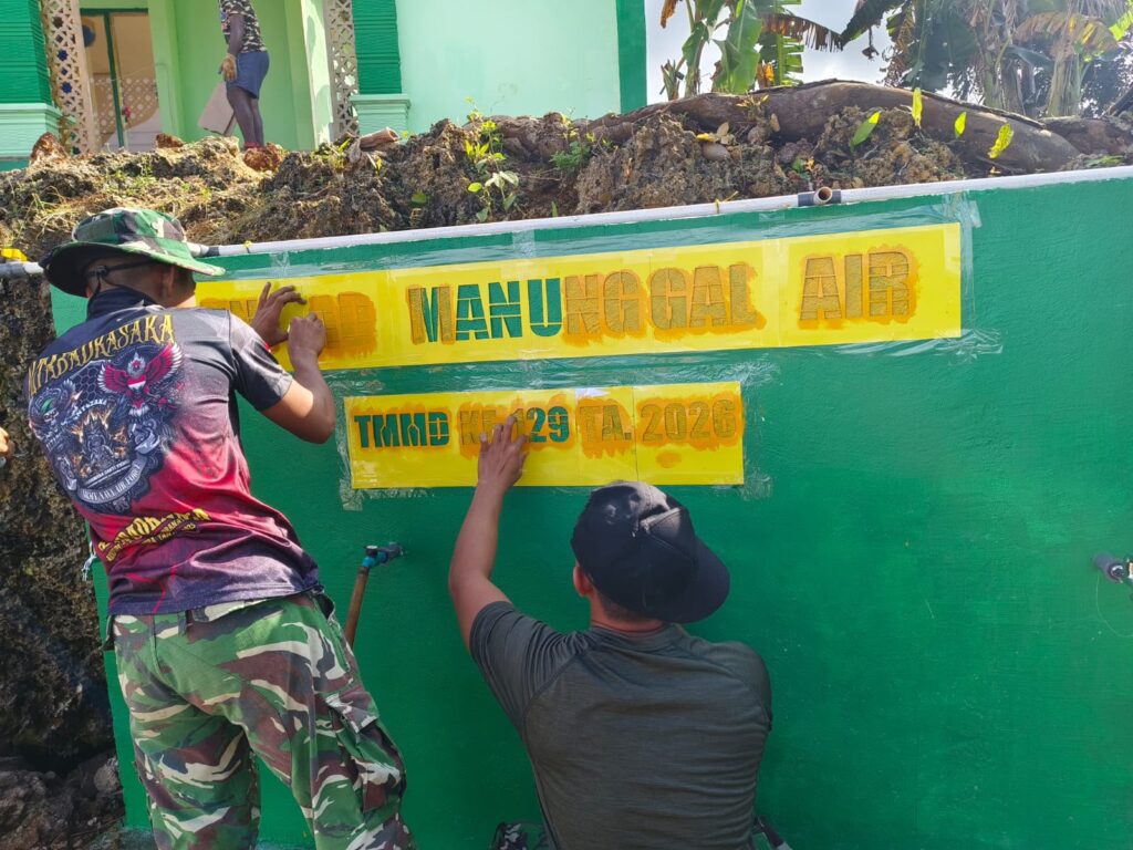 Pemasangan Stiker Program Air Bersih di Bak Penampungan TMMD ke-129